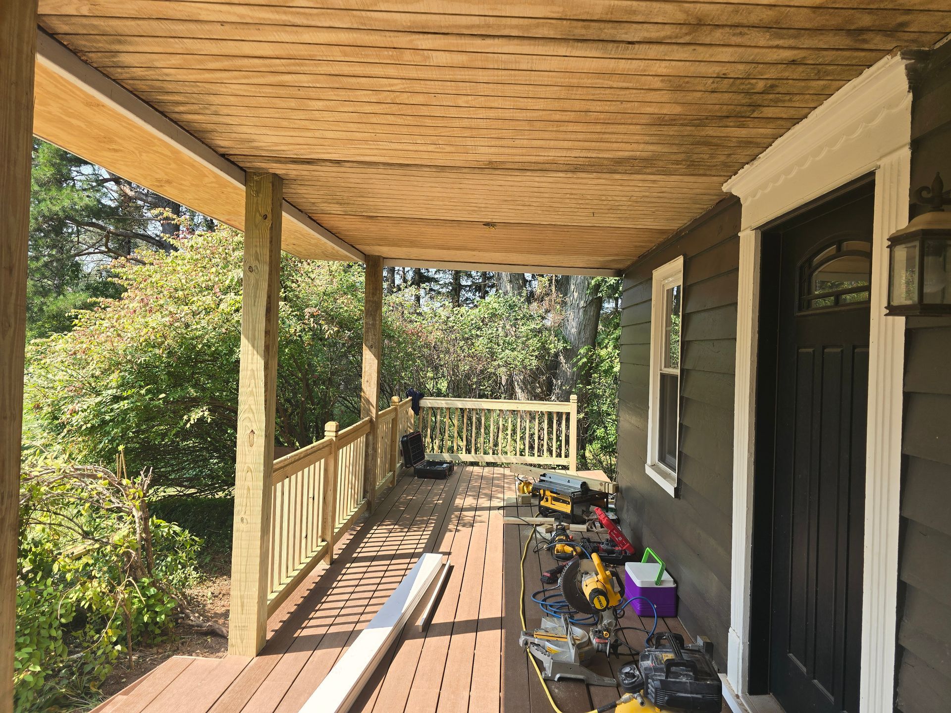 A wooden porch is being built on the side of a house.