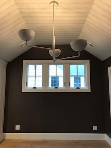 A room with a vaulted ceiling and a chandelier hanging from the ceiling.