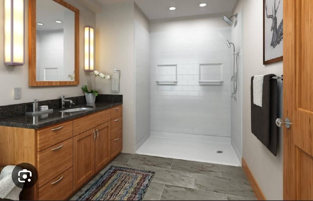 A bathroom with two sinks and a walk in shower