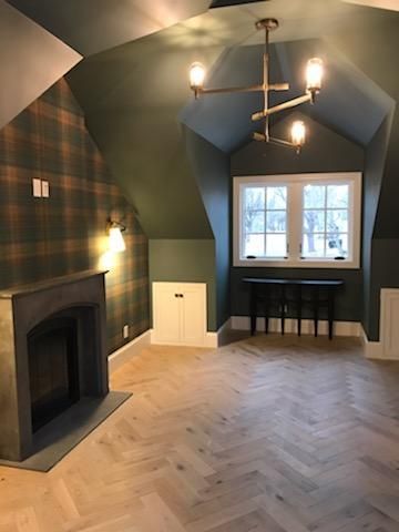 An empty room with a fireplace and a chandelier.
