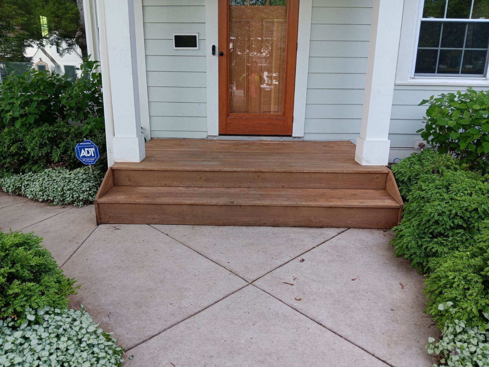 A white house with a wooden porch and steps