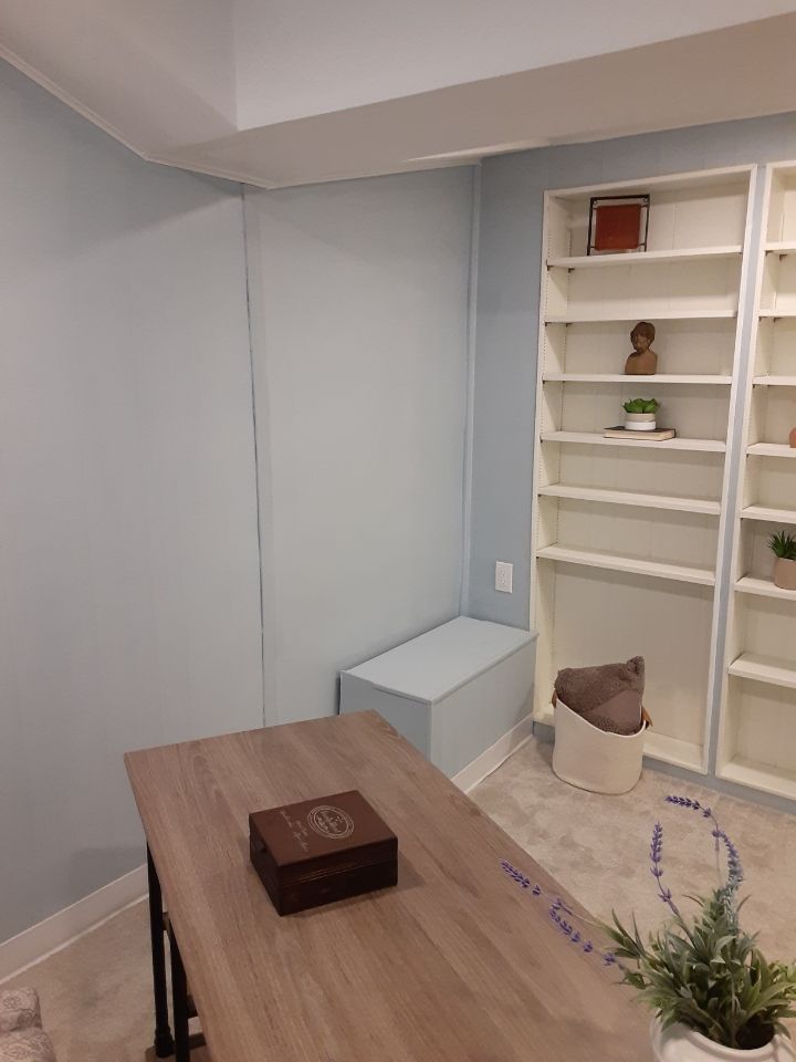 A room with a table , shelves and a bench.