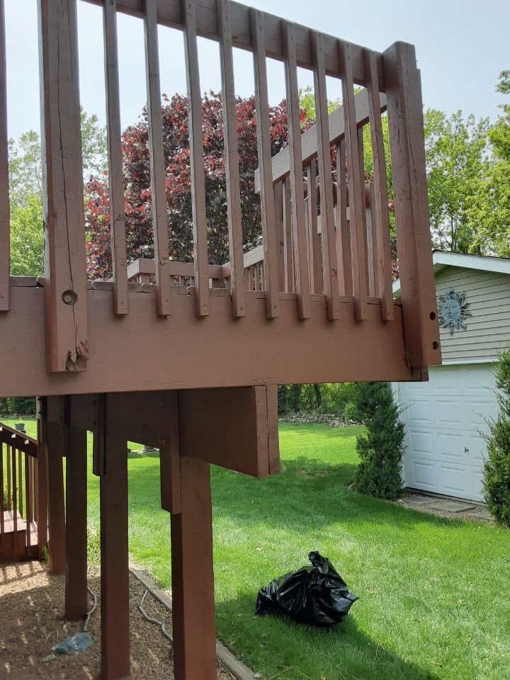 A wooden deck with a white garage in the background