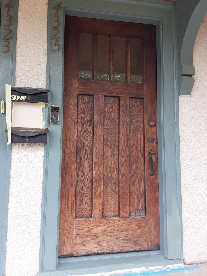 A wooden door on a house with a mailbox in front of it