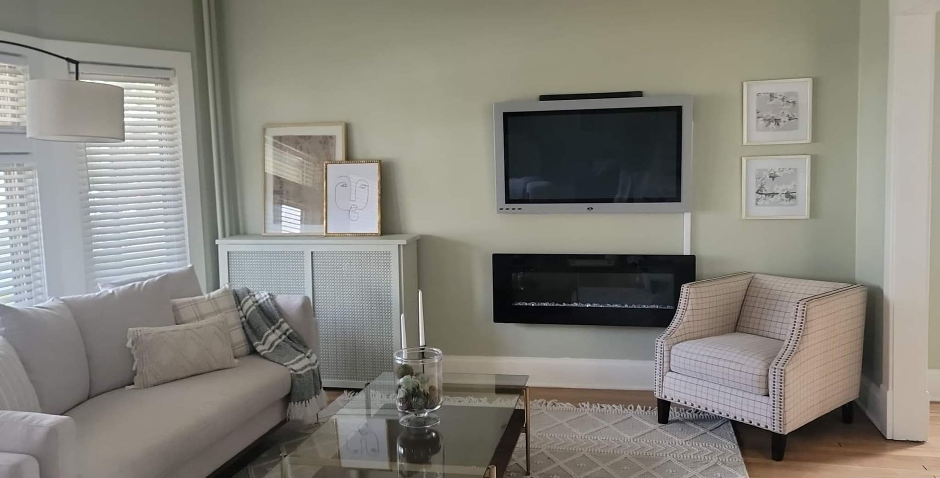 A living room with a fireplace and a flat screen tv