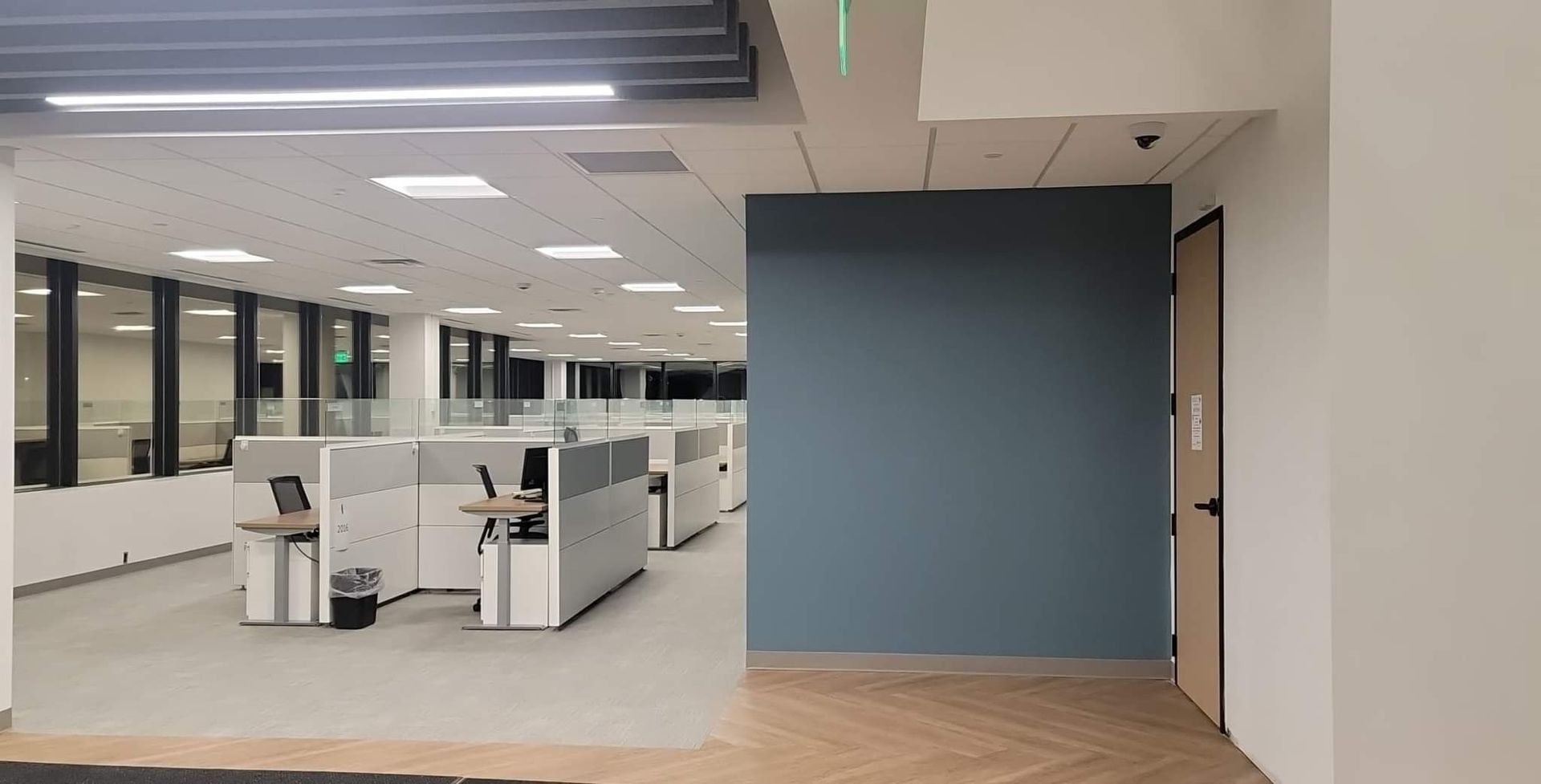 A large empty office with cubicles and a door.