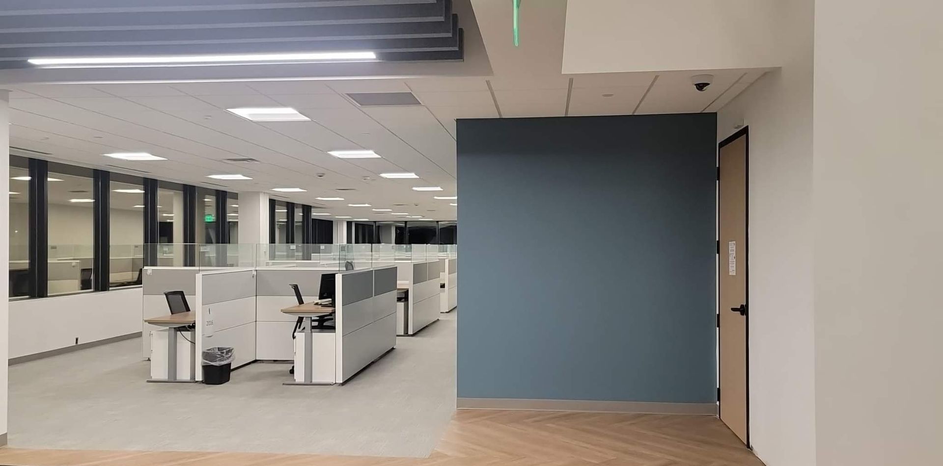 A large empty office with cubicles and a door.