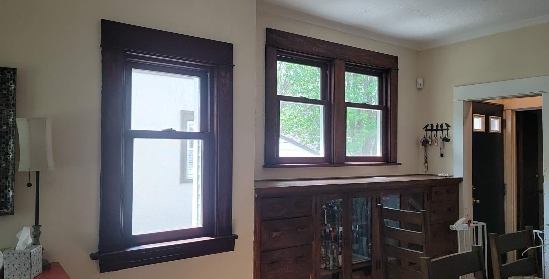 A living room with two windows and a dresser