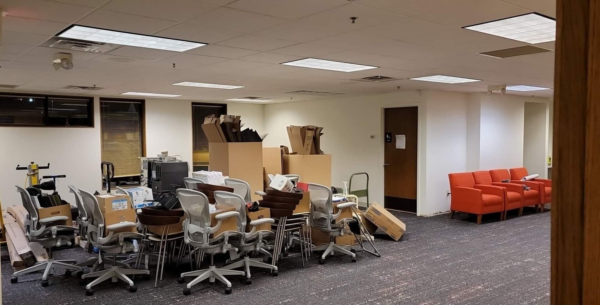 A room with a lot of chairs and boxes on the floor