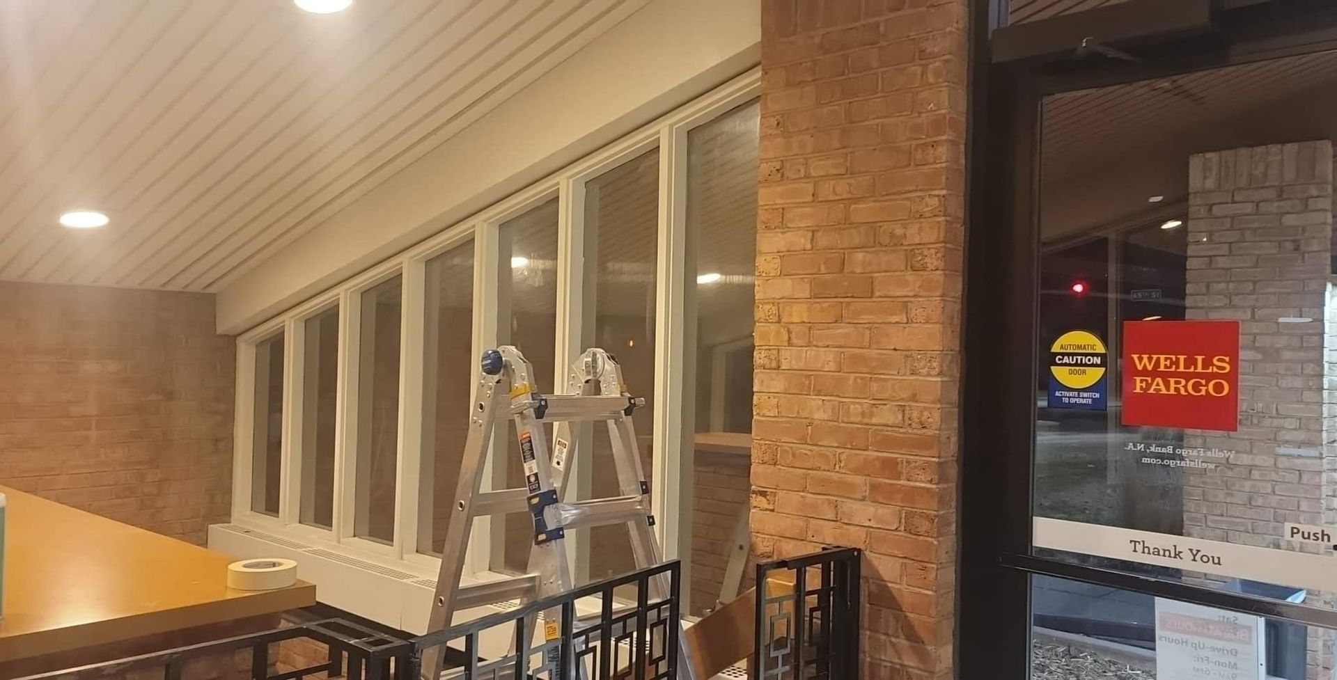 A ladder is sitting on the side of a building next to a window.