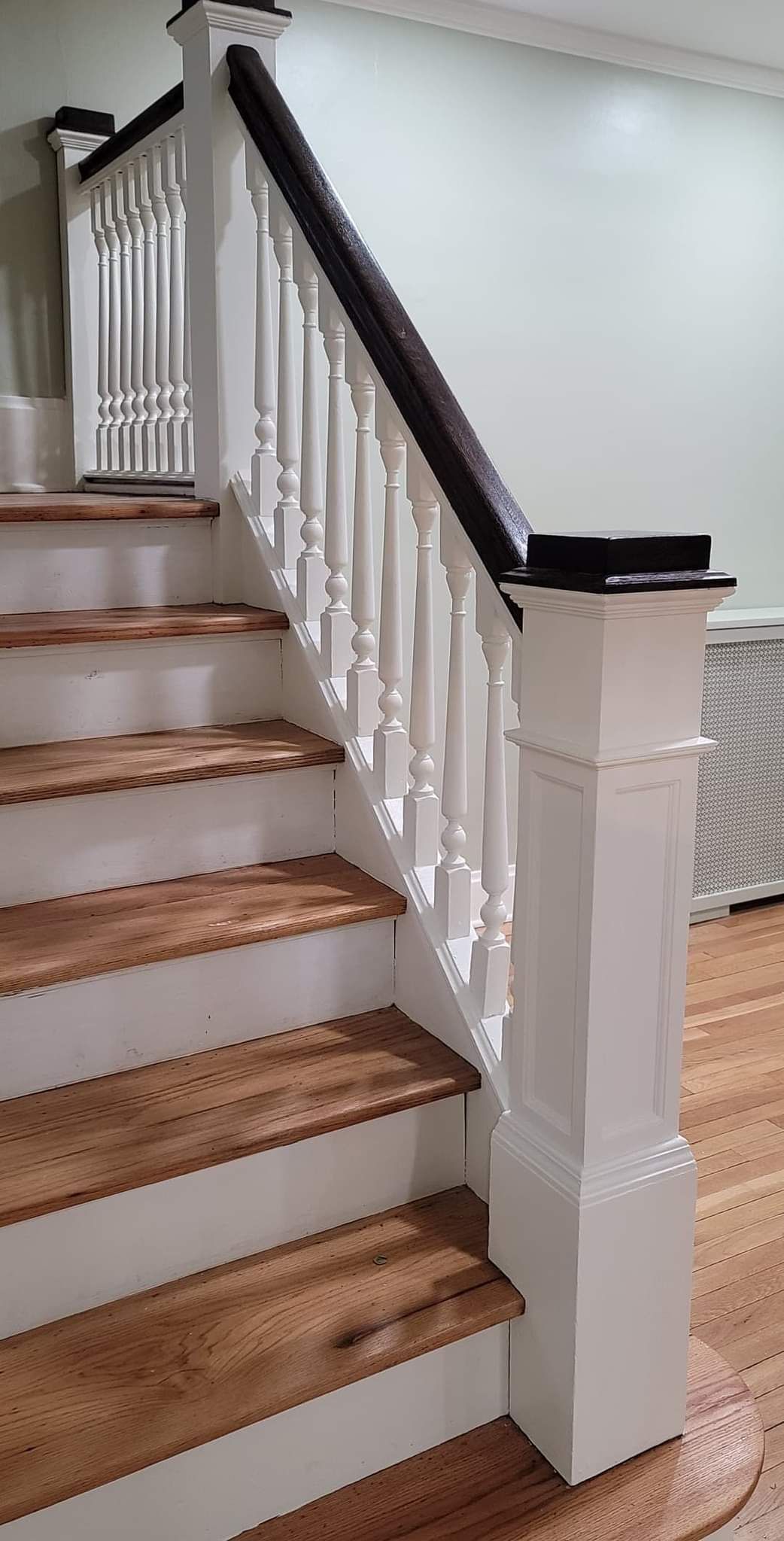 A staircase with wooden steps and a white railing in a house.