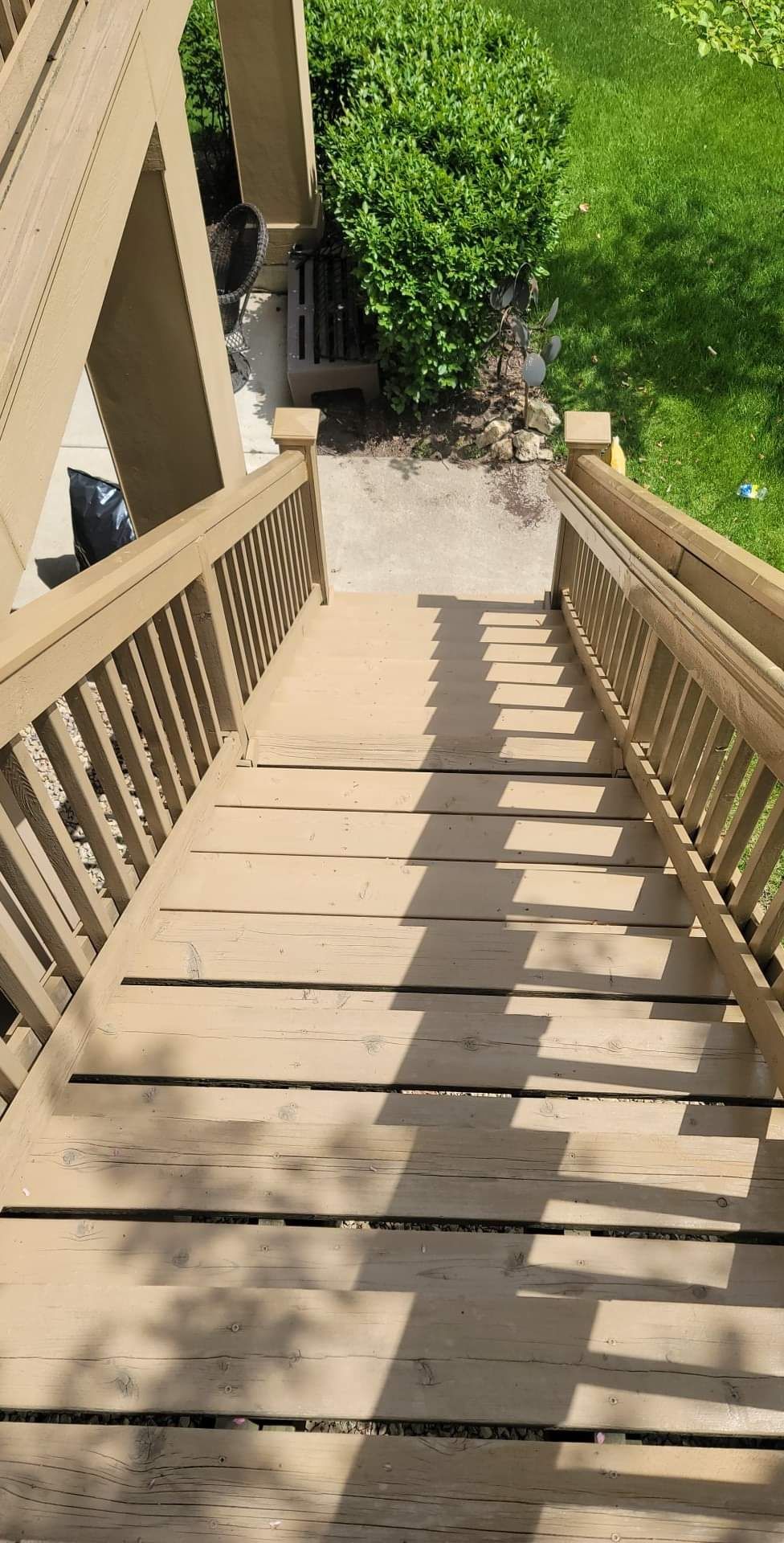A wooden staircase with a railing leading up to a balcony.