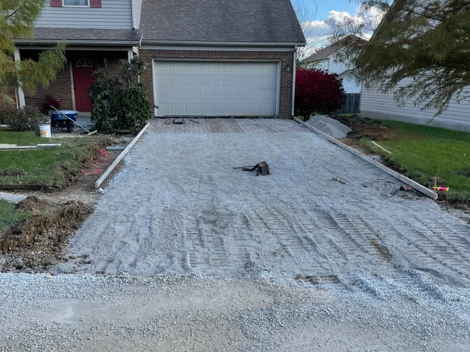 Construction site with red barn and orange cones.