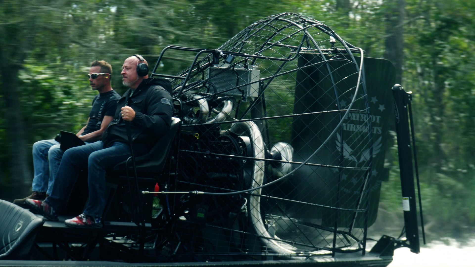 Diesel-powered airboat cutting across open water at high speed.