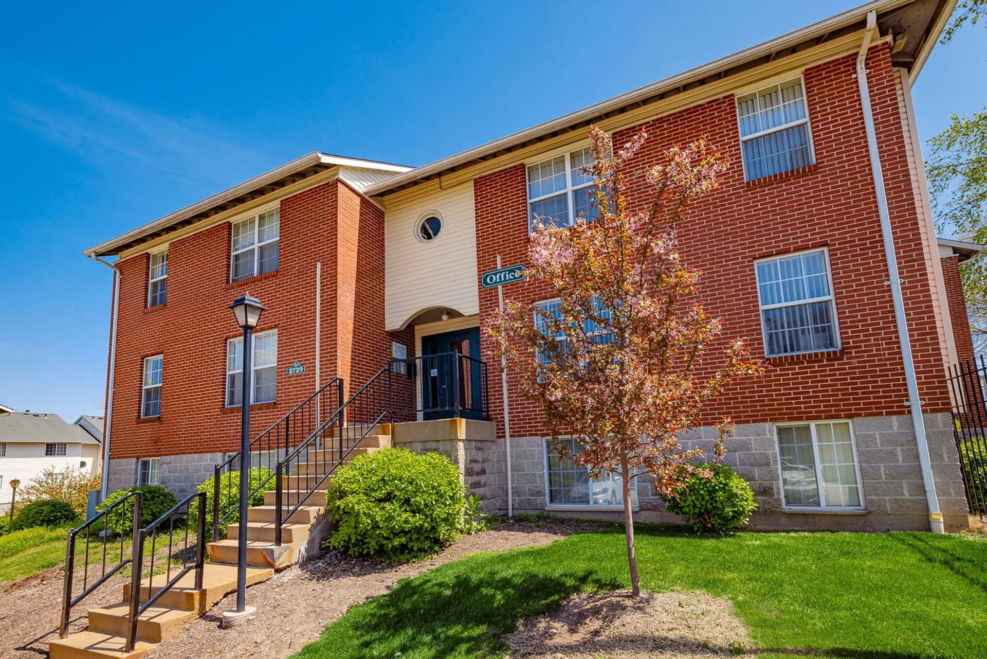 A large brick apartment building with stairs leading up to the front door.