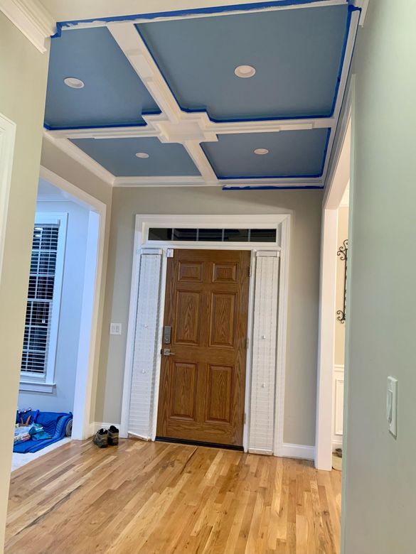 A hallway with a wooden door and a blue ceiling.