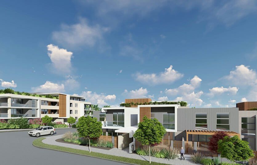 Residential buildings with modern architecture under a blue sky with clouds. A white car is driving on a road.