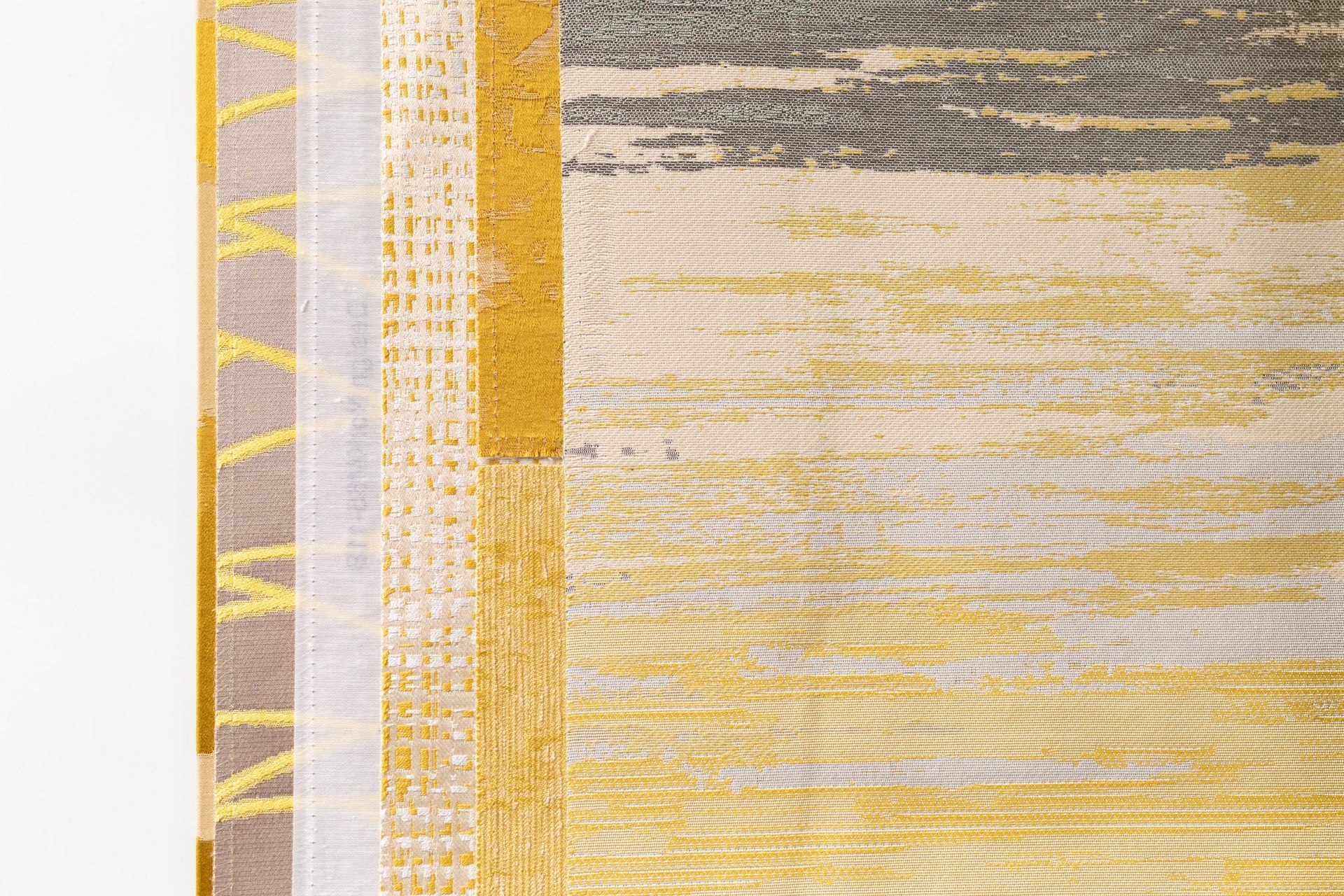 A close up of a yellow and gray rug on a white background.