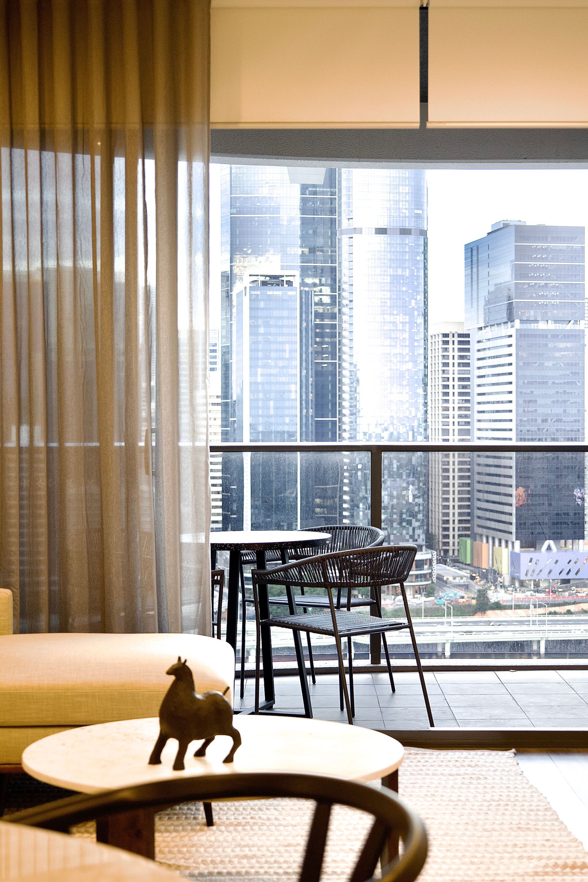 A living room with a balcony and a view of the city