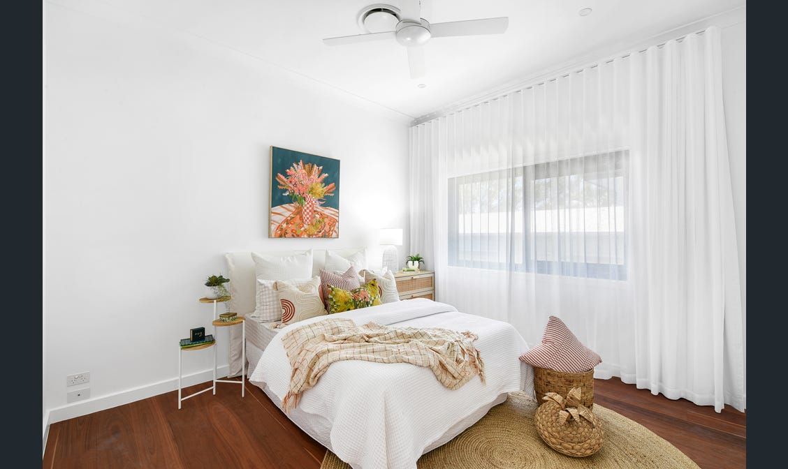 A bedroom with a bed and a ceiling fan.