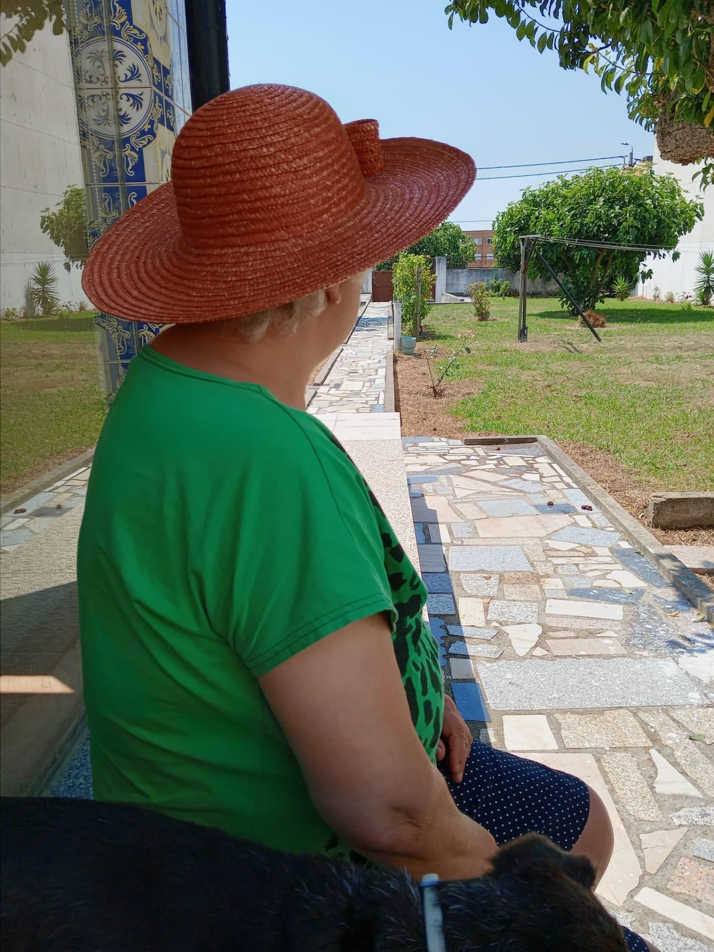 Uma mulher usando um chapéu de palha e uma camisa verde