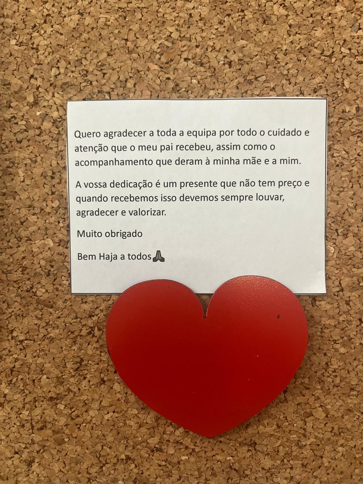 Um quadro de cortiça com um bilhete e um coração nele.