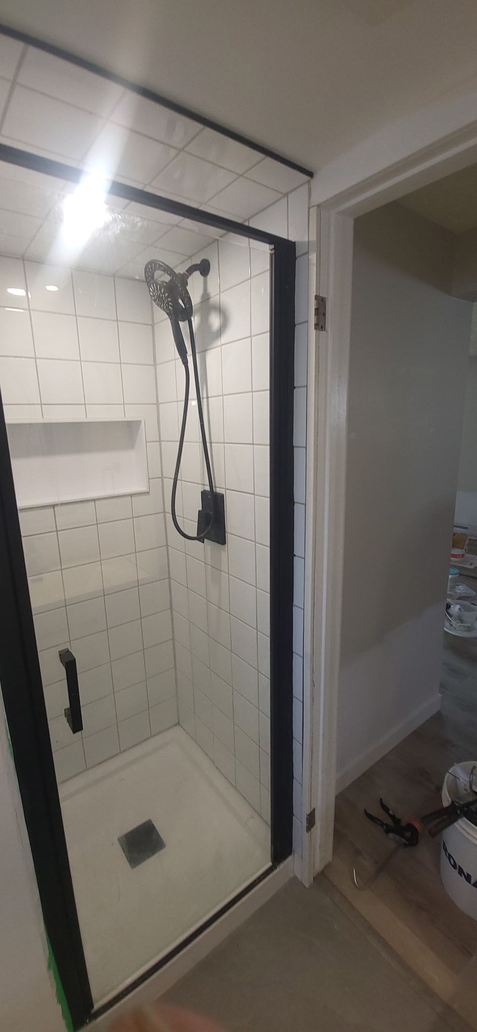 Une salle de bain avec une douche à l'italienne avec un cadre noir.