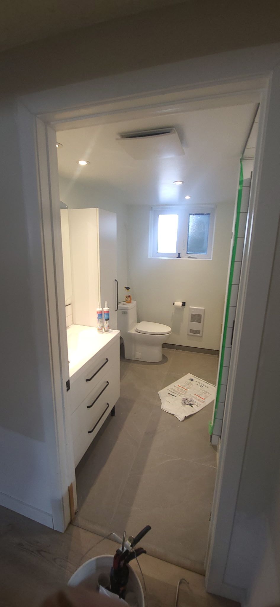 Une salle de bain avec toilettes, lavabo et fenêtre.
