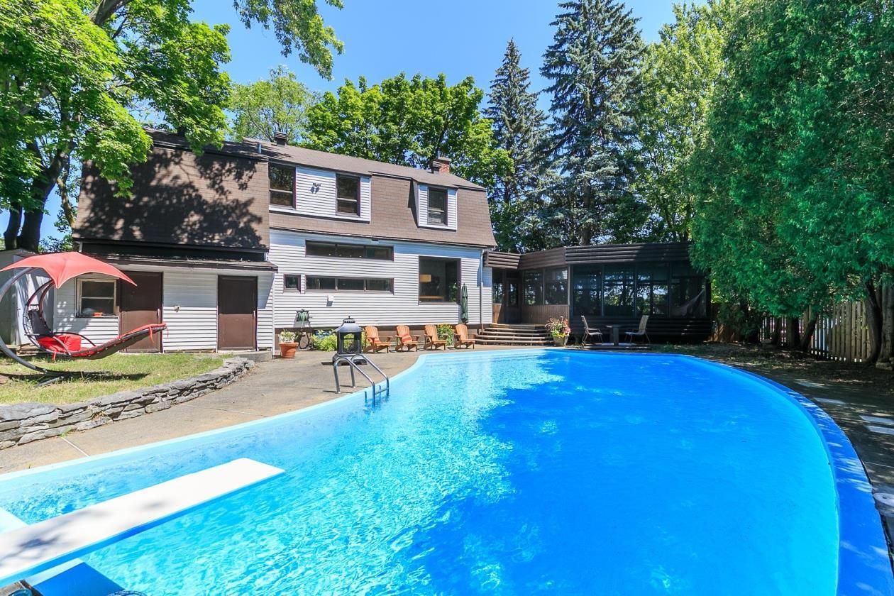 Une grande piscine se trouve dans l'arrière-cour d'une maison.