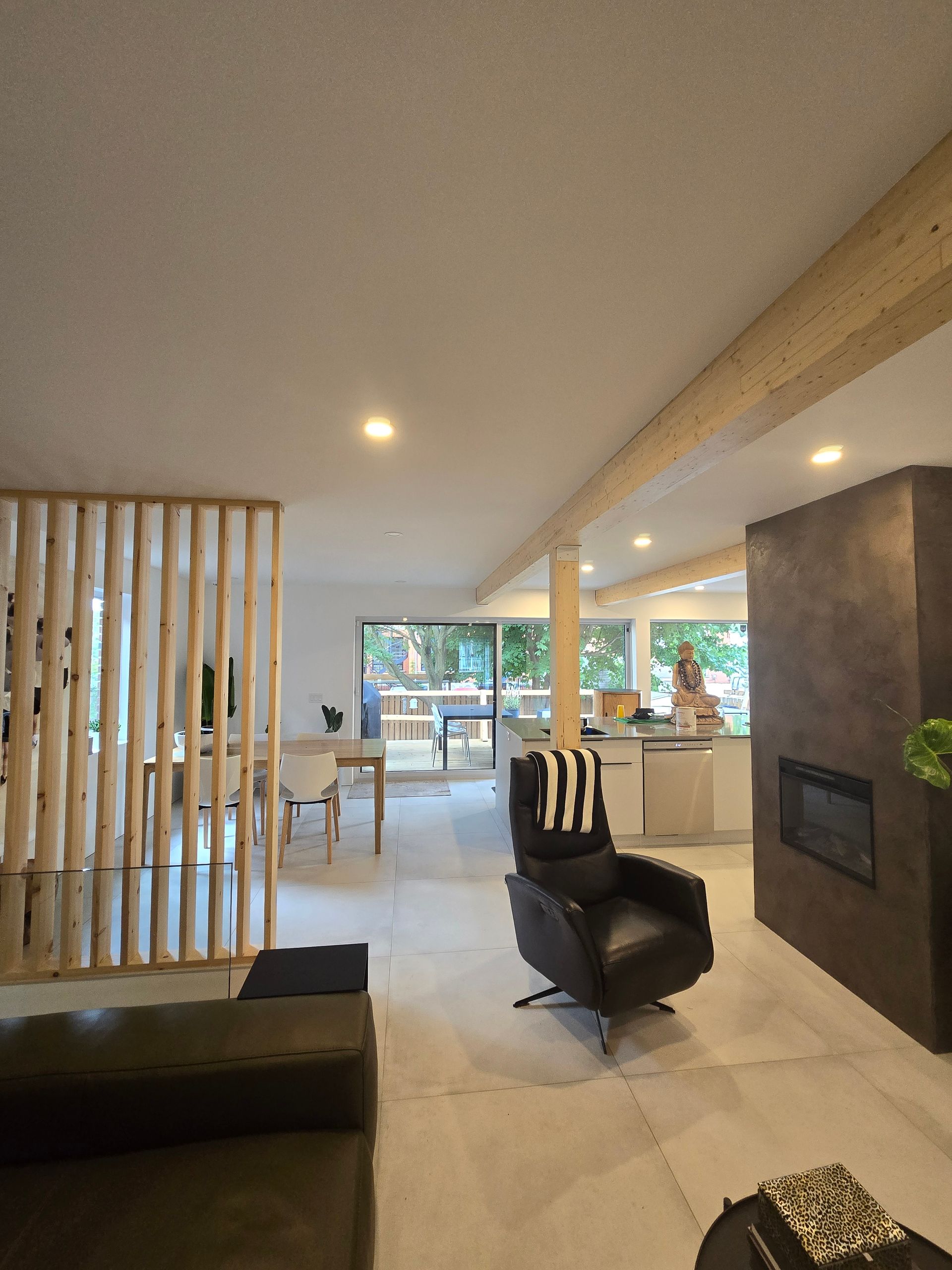 Un salon avec un canapé noir et une chaise noire