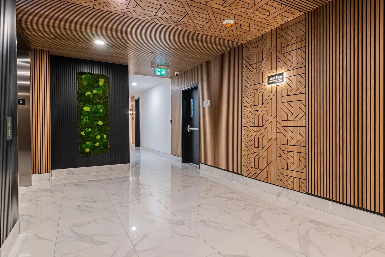 Un couloir dans un immeuble avec un sol en marbre et des murs en bois.