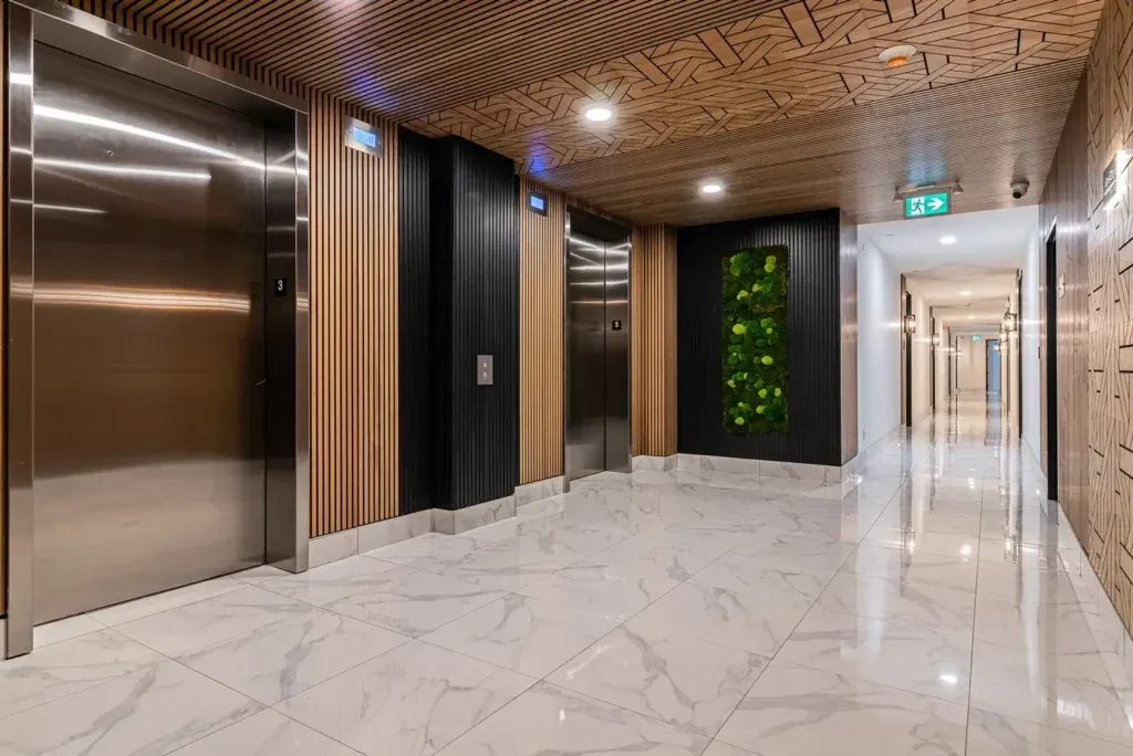 Il y a deux ascenseurs dans le couloir d'un immeuble.