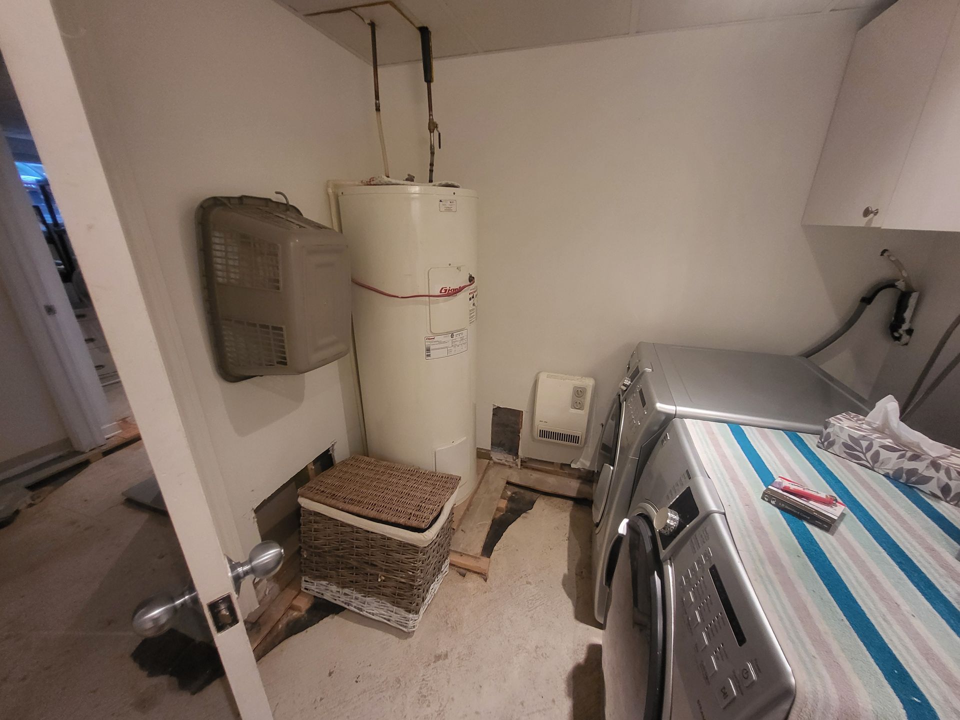 Une buanderie avec laveuse et sécheuse et un chauffe-eau.