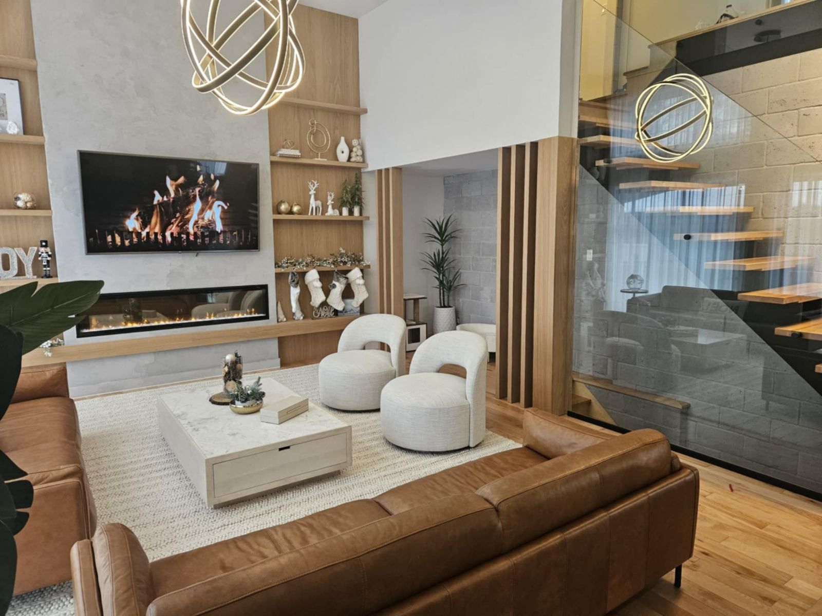 Un salon avec un canapé, des chaises, une table basse et une télévision.