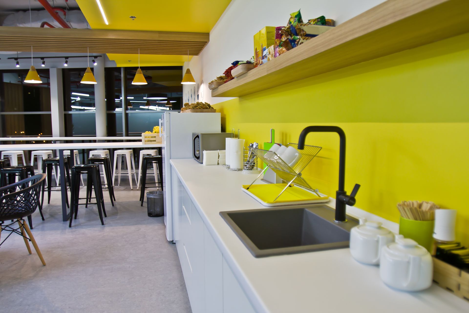 Une cuisine avec un évier et un mur jaune