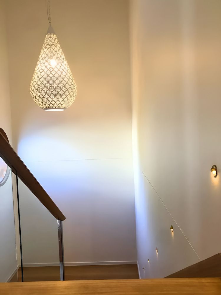 A Staircase With A Light Hanging From The Ceiling — Reef Electrical in Cannonvale, QLD