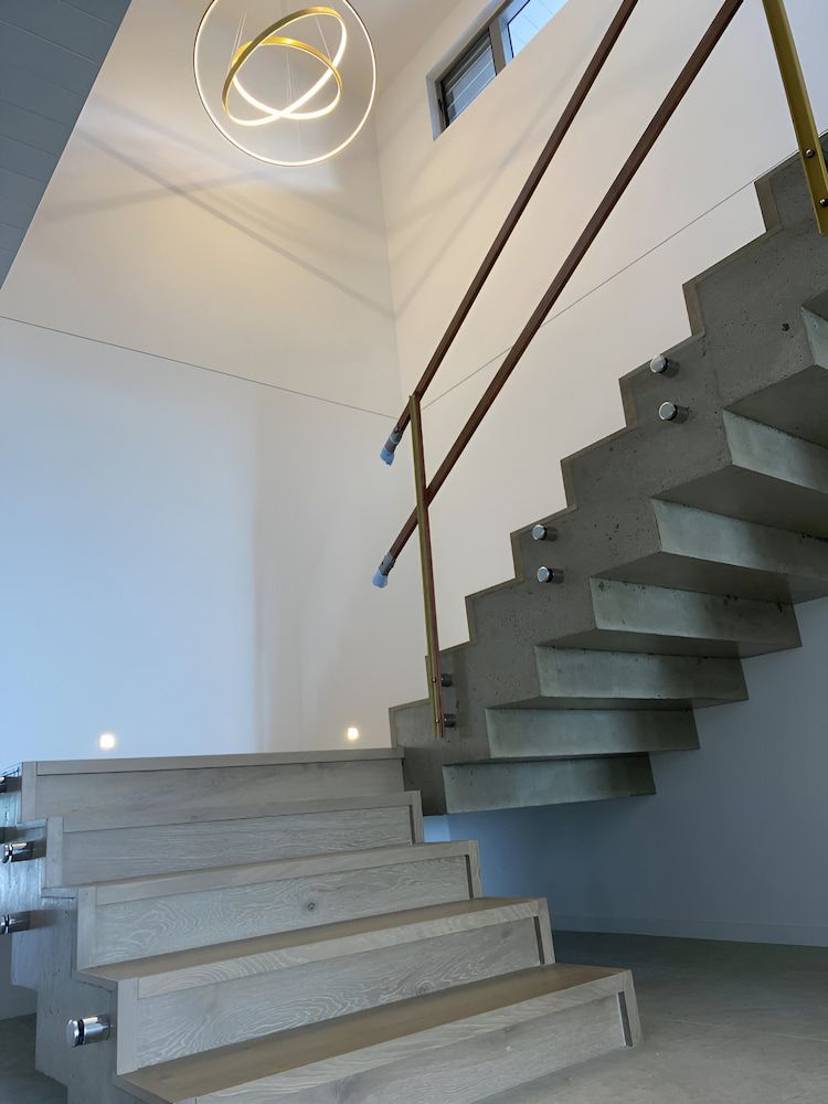 A Staircase With Wooden Steps And A Metal Railing — Reef Electrical in Cannonvale, QLD