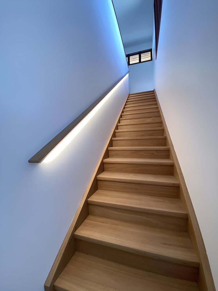 A Set Of Wooden Stairs Leading Up To A Window — Reef Electrical in Cannonvale, QLD