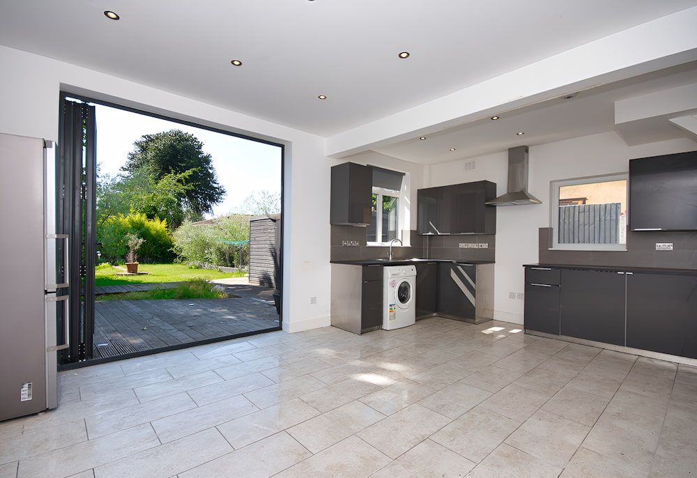 An Empty Kitchen With A Large Sliding Glass Door — Reef Electrical in Cannonvale, QLD