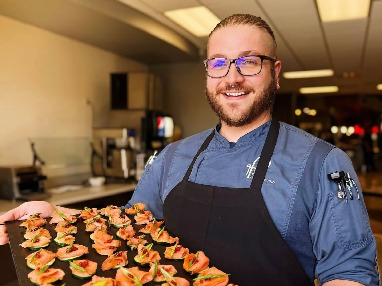 A man in a chef 's hat is posing for a picture with two other chefs