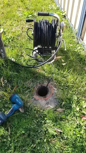 A hose reel is sitting in the grass next to a hole in the ground. — Jobs2BDone in Bensville, NSW