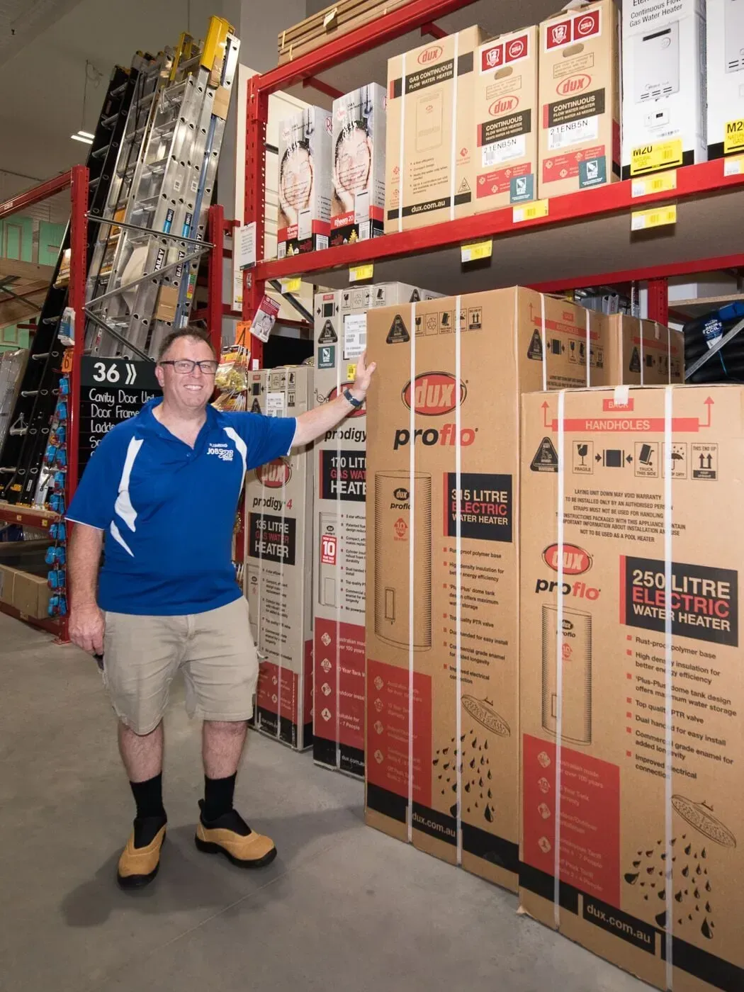 A man in a blue shirt is standing in front of boxes in a store — Jobs2BDone in Umina, NSW