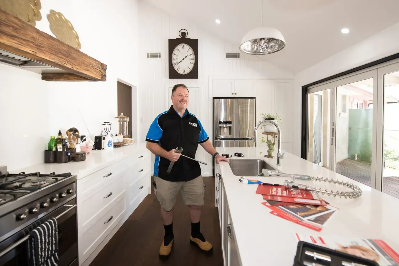 A Plumber Is Fixing A Sink With A Hose  — Jobs2BDone in Gosford, NSW