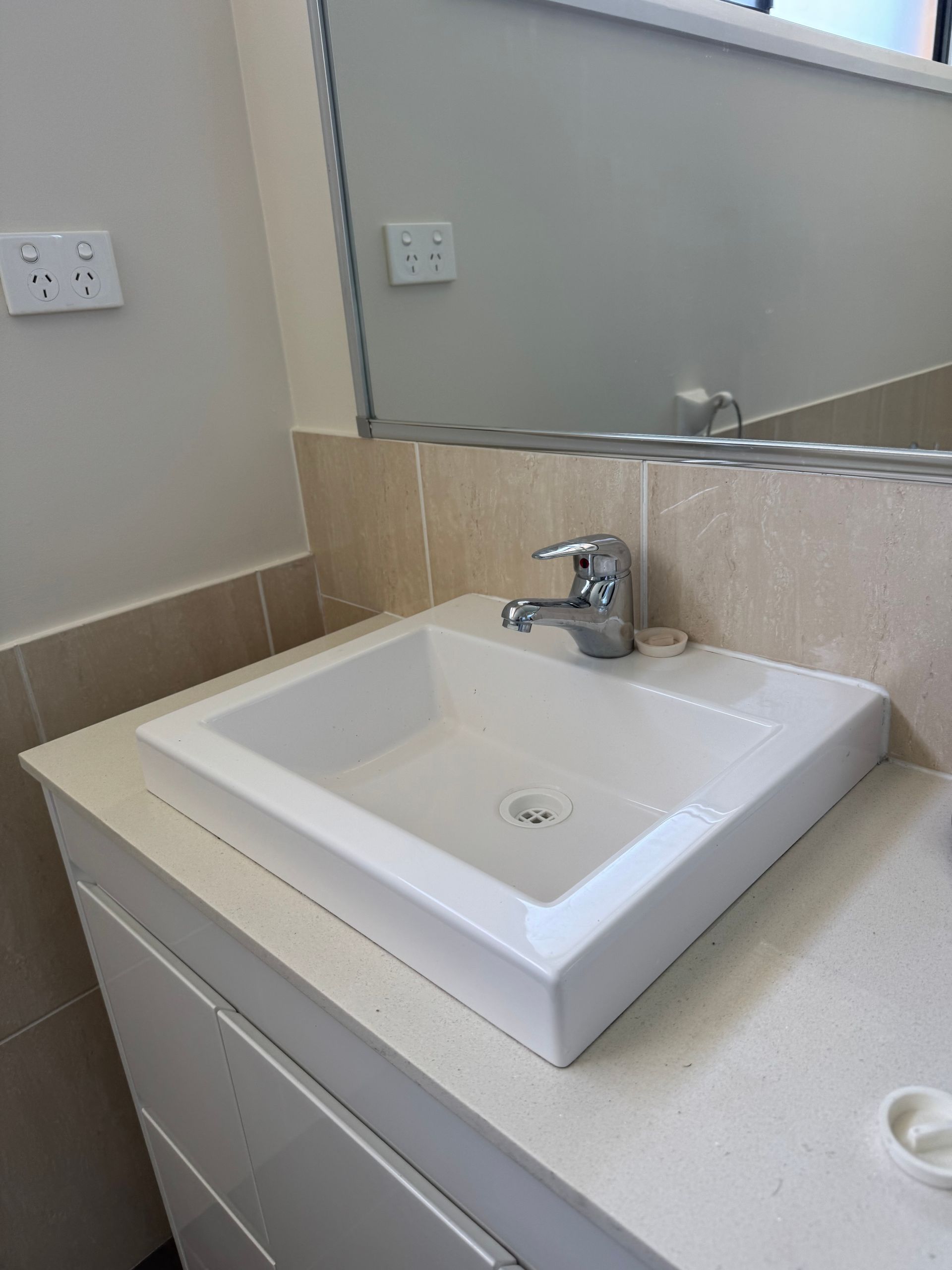 A bathroom sink with a faucet and a mirror. — Jobs2BDone in Woy Woy, NSW