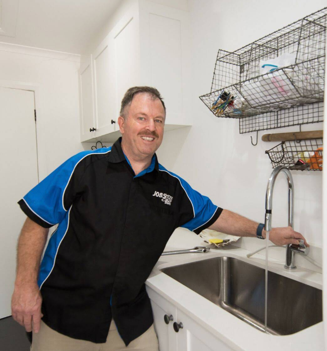 A man in a black and blue shirt is standing next to a sink  — Jobs2BDone in Woy Woy, NSW
