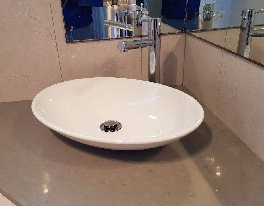 A bathroom sink with a faucet and a mirror — Jobs2BDone in Kincumber, NSW