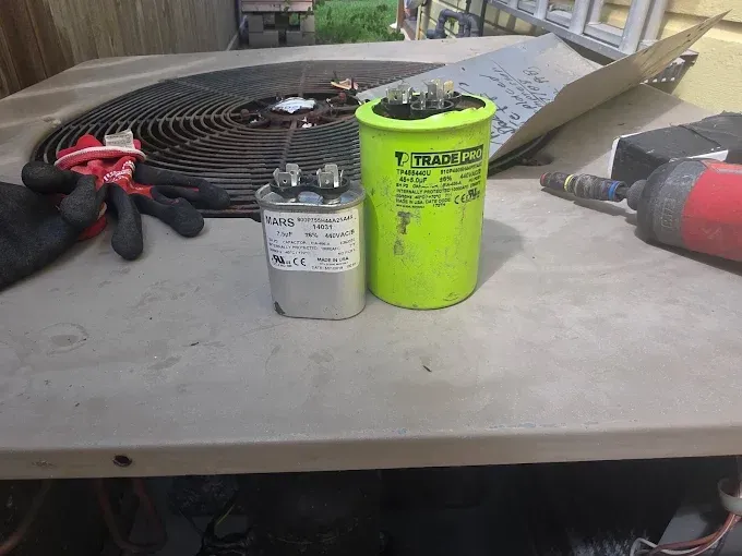 Tools and a neon green container on a workbench, with coiled hose and a power tool in the background