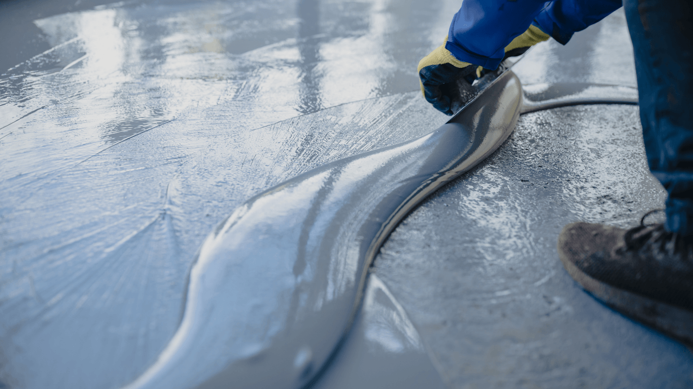Close-up of epoxy coating being spread smoothly across a concrete surface with a trowel during an epoxy flooring service in Glendale, AZ