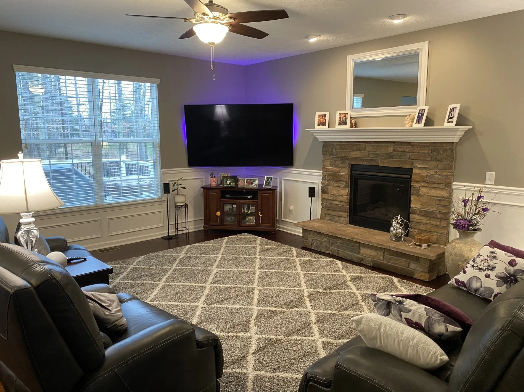 A living room with a fireplace and a flat screen tv.