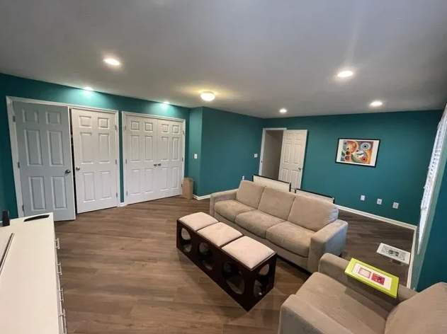 A living room with a couch , chair and ottoman.